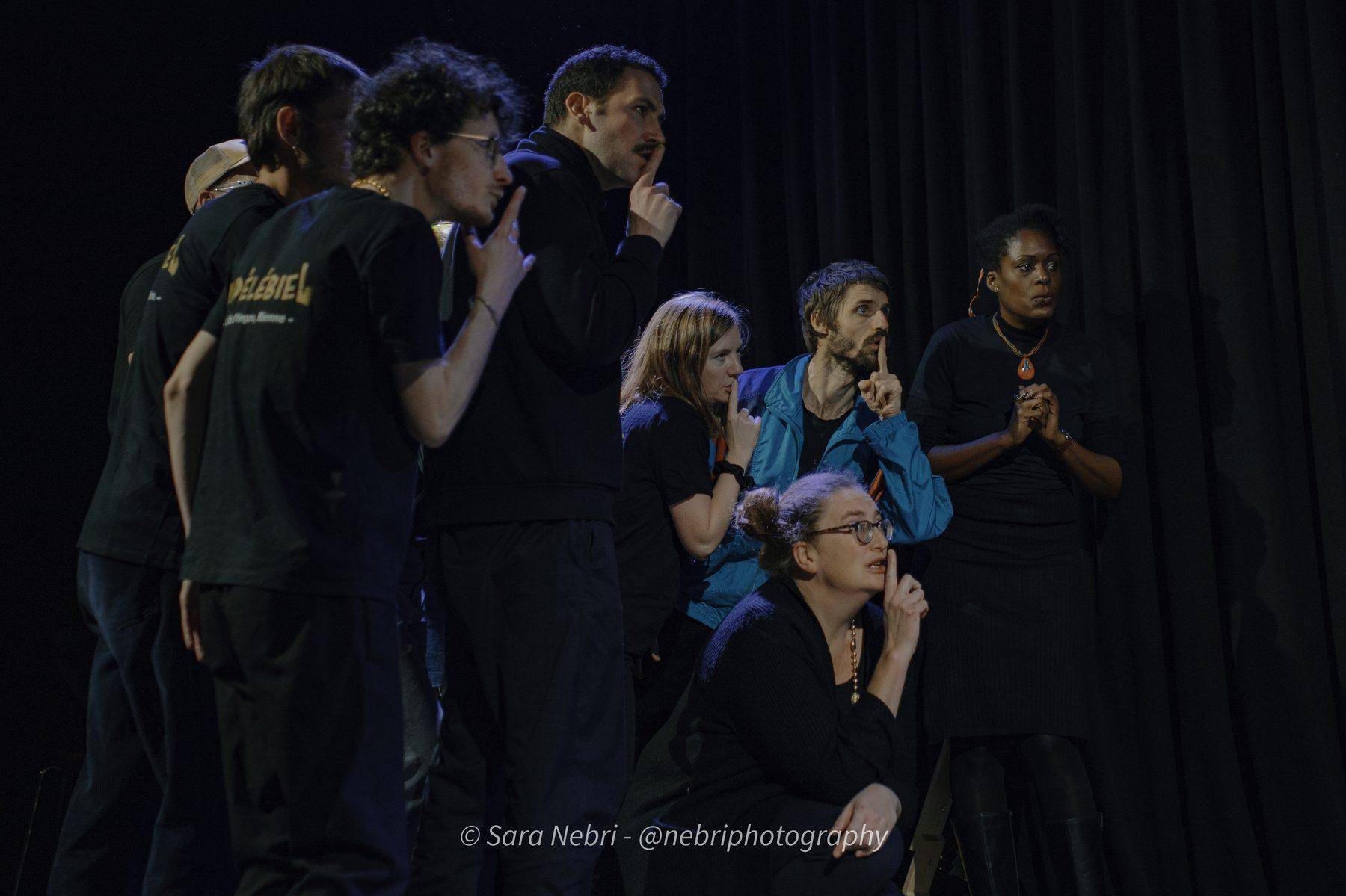 Les comédien·nes d'IndéléBiel sur scène, doigt sur la bouche, lors d'un spectacle